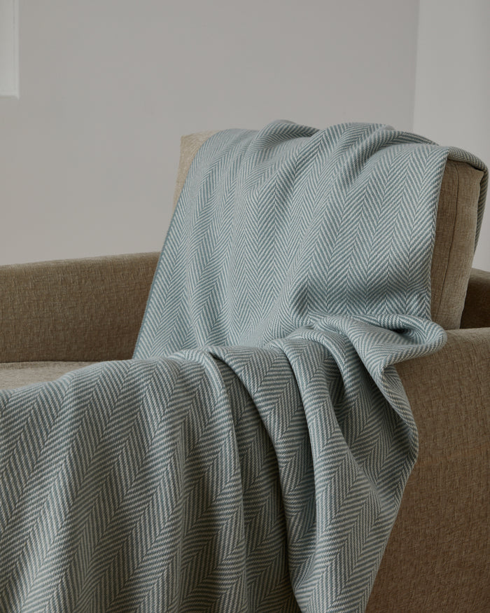 Foxford Achill Cashmere and Lambswool Throw draped over a chair